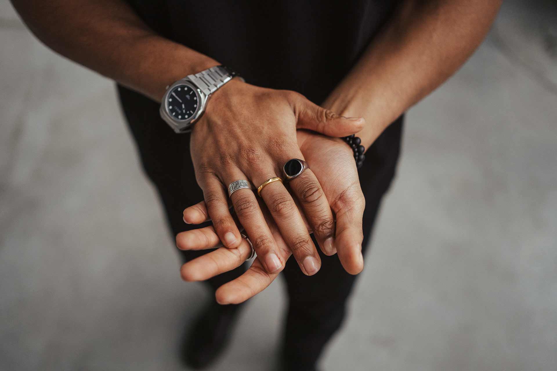 golden jewelry mixed with silver jewelry in man's hand